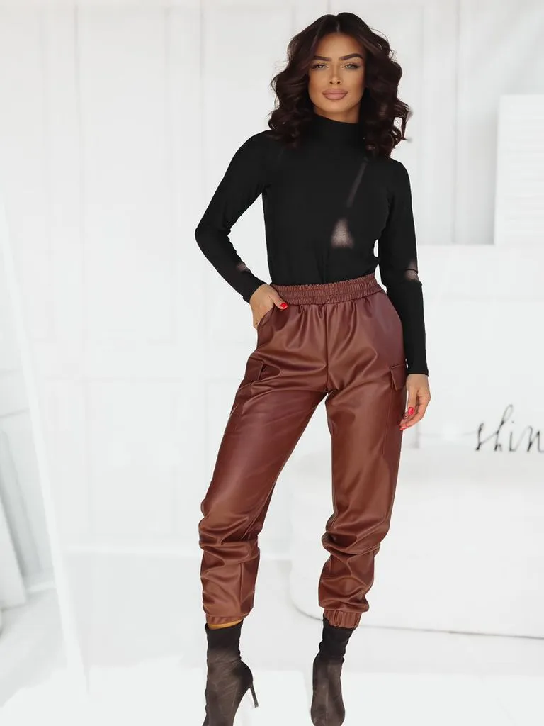 Women's combat trousers made of eco-leather with elastic cuffs.